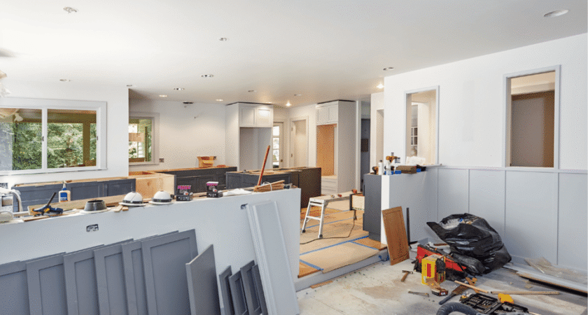 Open-plan home interior under renovation with drywall, tools and materials